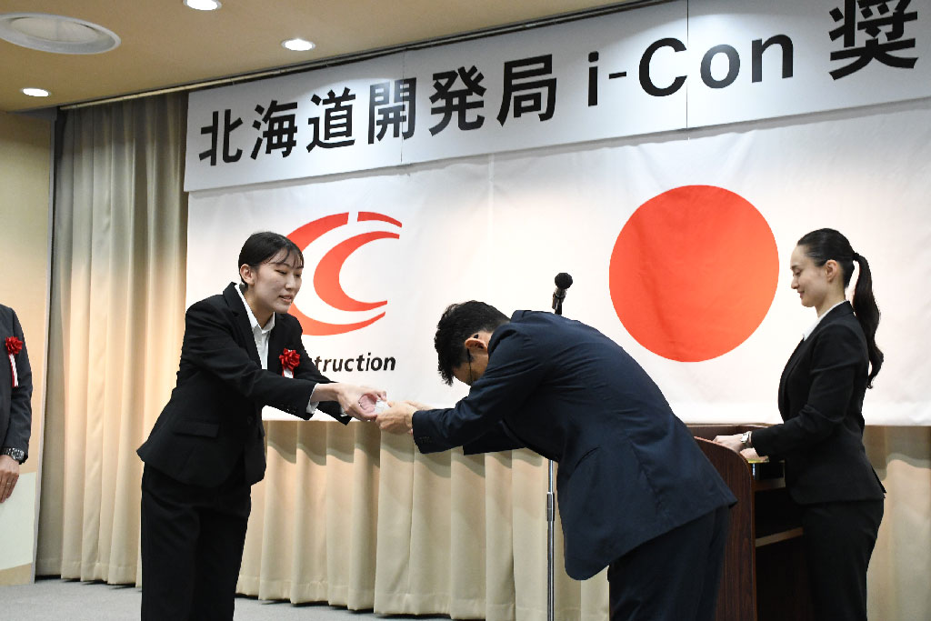 遠藤局長から記念バッヂを受け取る担当技術者